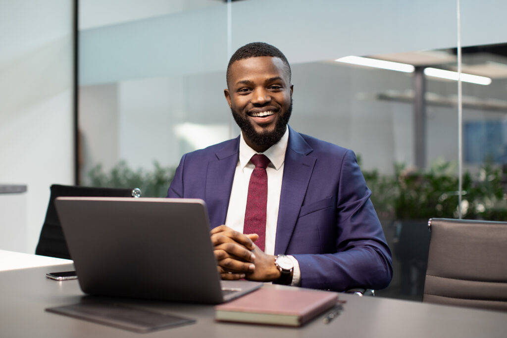 Cheerful Black Businessman Posing At Workdesk In Office - ADF PRO